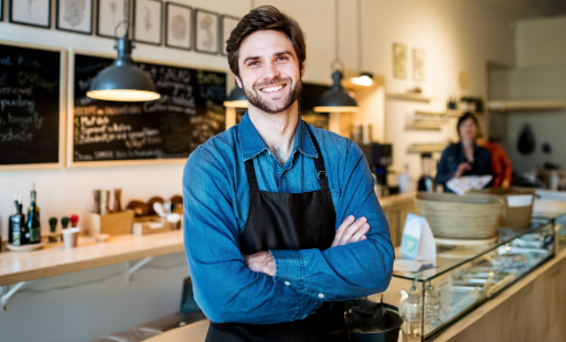 Właściciel małej firmy w kawiarni korzystający z promocji konta firmowego w banku